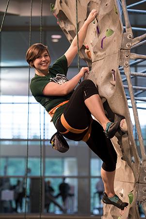 Woman climbing rock wall in Ping Rec Center